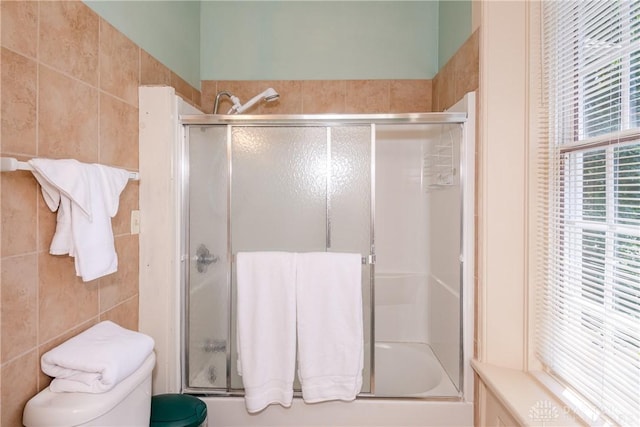 bathroom featuring toilet and tile walls