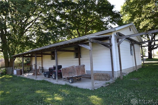 view of property exterior with a lawn and a patio area