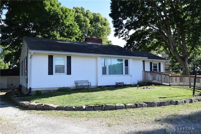 view of front of home with a front yard and a wooden deck