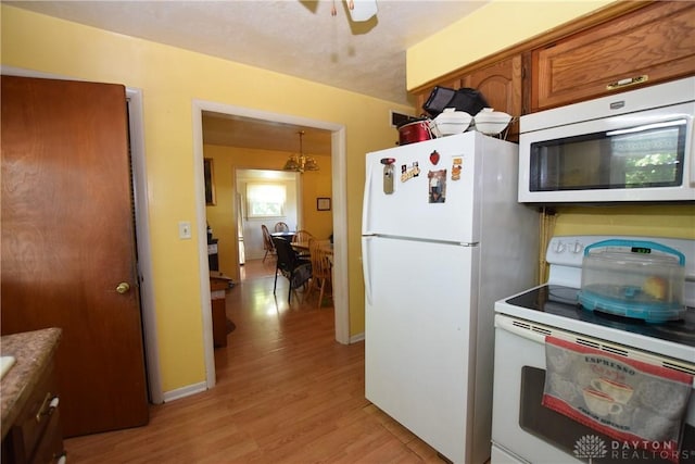 kitchen with ceiling fan, white appliances, and light wood-type flooring