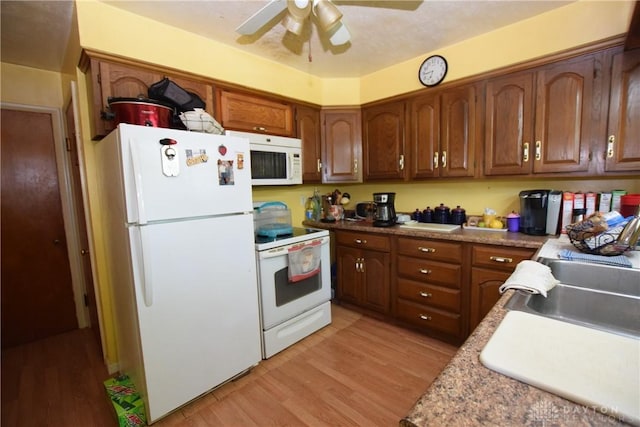 kitchen featuring ceiling fan, white appliances, and light hardwood / wood-style flooring