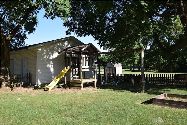 view of playground with a shed and a lawn