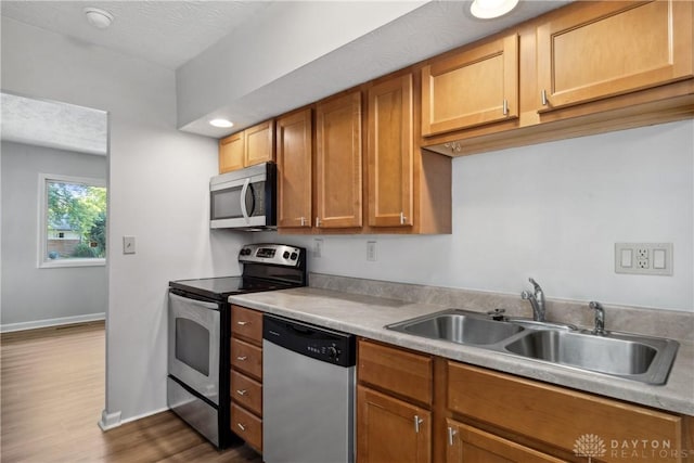 kitchen featuring appliances with stainless steel finishes, dark hardwood / wood-style floors, sink, and a textured ceiling