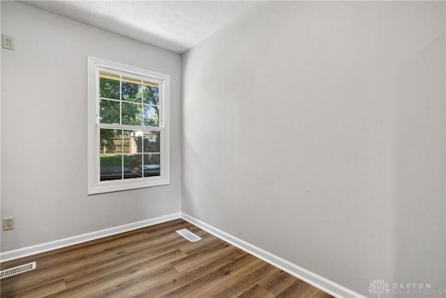 spare room with hardwood / wood-style flooring and a textured ceiling