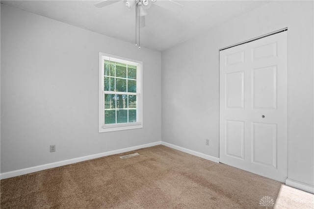 empty room with light colored carpet and ceiling fan