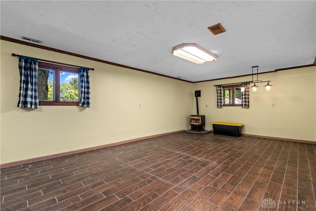 basement featuring ornamental molding, a wood stove, and a textured ceiling