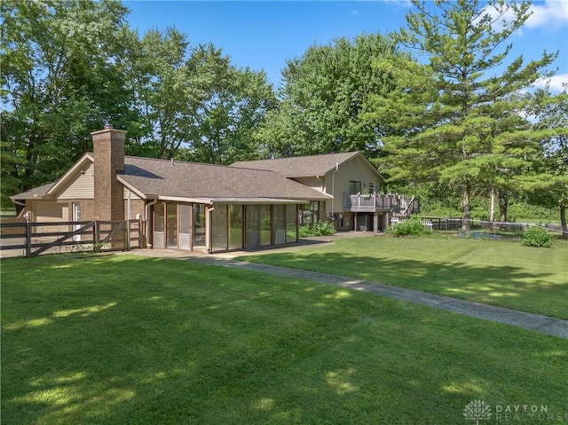 back of property featuring a lawn and a sunroom