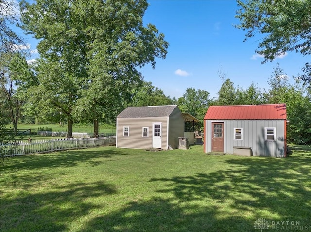 rear view of house with a storage shed and a yard