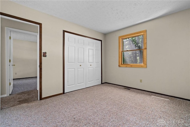 unfurnished bedroom with a closet, a textured ceiling, and carpet