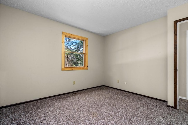 empty room featuring carpet floors and a textured ceiling