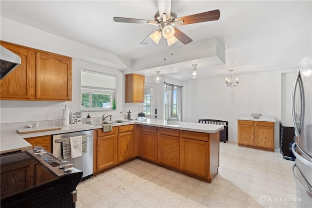 kitchen featuring ceiling fan with notable chandelier, sink, kitchen peninsula, and stainless steel appliances