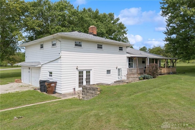 back of property featuring a lawn, covered porch, and a garage