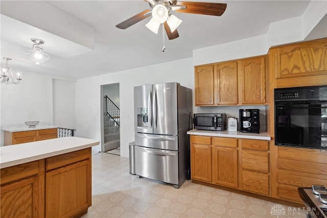 kitchen with stainless steel appliances and ceiling fan with notable chandelier