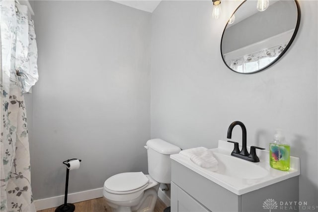 bathroom with wood-type flooring, vanity, and toilet