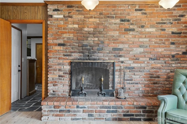 interior details with wood-type flooring and a brick fireplace