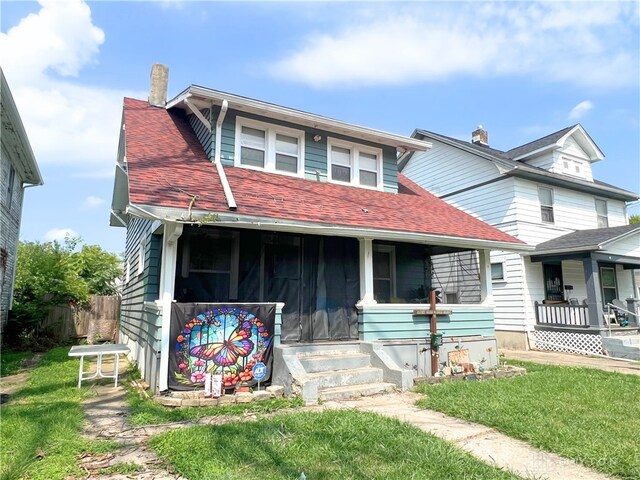 view of front of house with covered porch and a front lawn