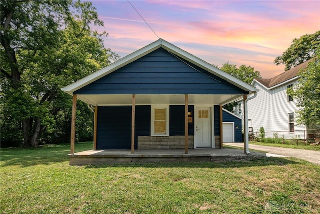 bungalow-style house with a lawn and covered porch