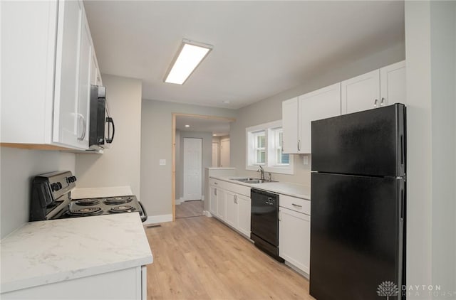 kitchen with white cabinetry, sink, black appliances, and light wood-type flooring