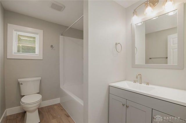 full bathroom featuring hardwood / wood-style floors, vanity, toilet, and tub / shower combination