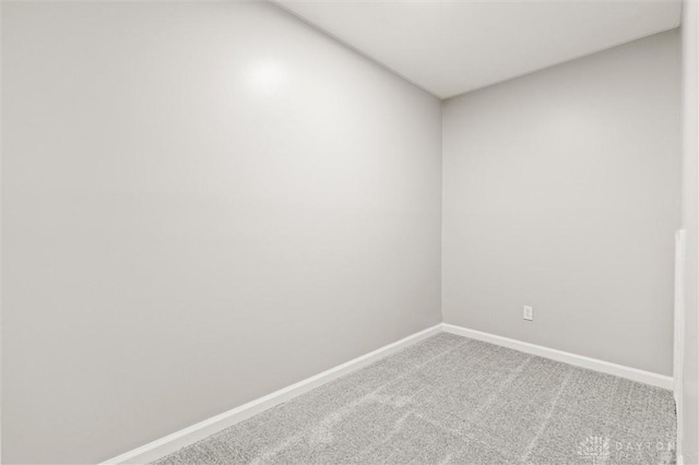 empty room featuring carpet and baseboards