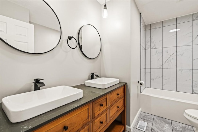 bathroom featuring visible vents, double vanity, a sink, and toilet