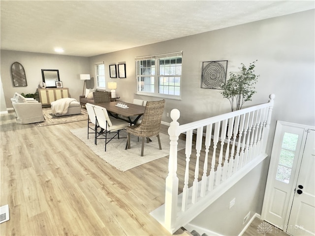 dining space featuring wood finished floors, visible vents, and baseboards