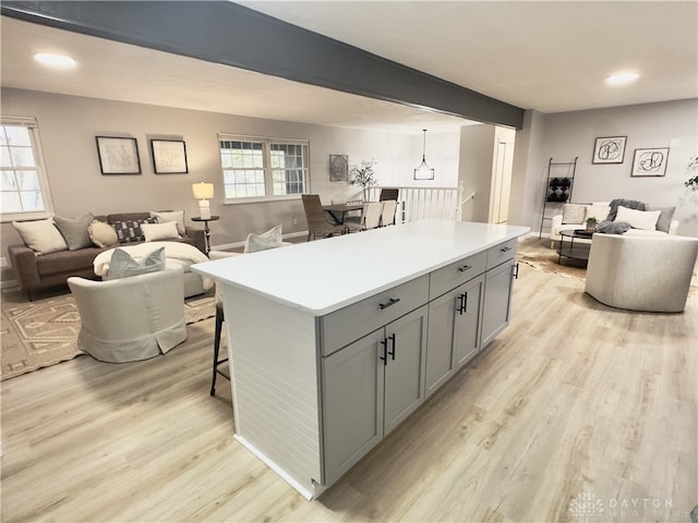 kitchen with light wood-type flooring, open floor plan, a healthy amount of sunlight, and gray cabinetry