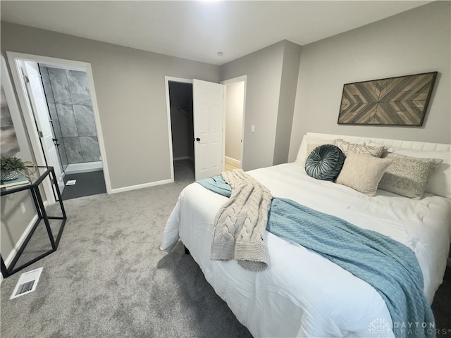 bedroom with visible vents, baseboards, ensuite bathroom, carpet, and a spacious closet