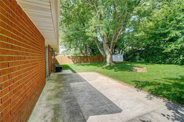 view of yard with a storage unit and a patio area