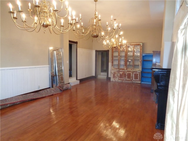 unfurnished living room with dark hardwood / wood-style floors and a chandelier