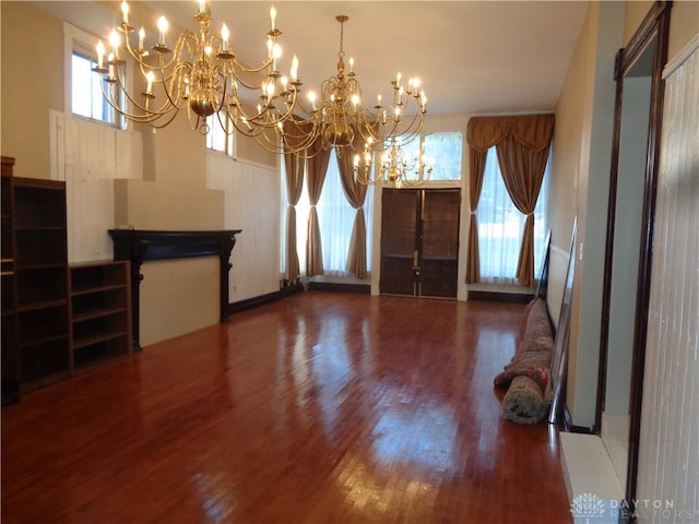 unfurnished dining area with an inviting chandelier and hardwood / wood-style flooring