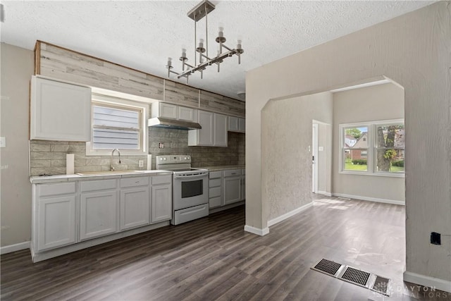 kitchen featuring sink, hanging light fixtures, dark hardwood / wood-style floors, white range with electric stovetop, and decorative backsplash