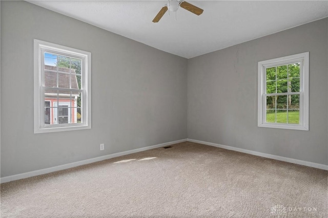 empty room featuring ceiling fan, a healthy amount of sunlight, and carpet flooring