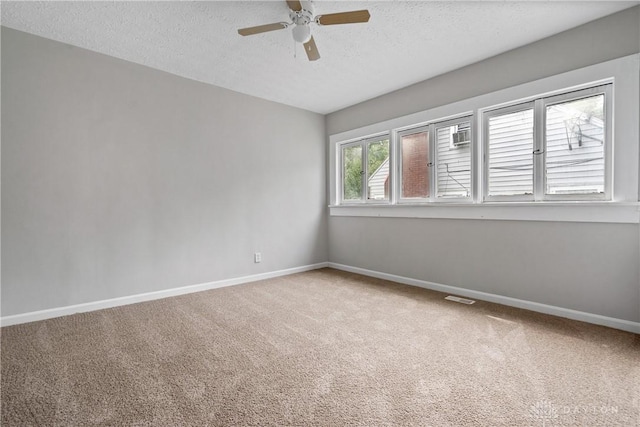 carpeted empty room with ceiling fan and a textured ceiling