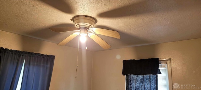 details with ceiling fan and a textured ceiling