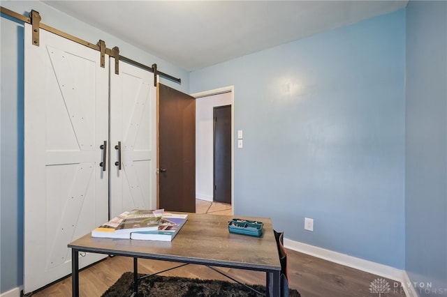 office featuring light hardwood / wood-style floors and a barn door