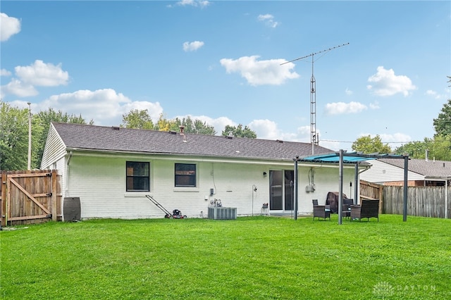 rear view of house featuring a yard and central AC unit