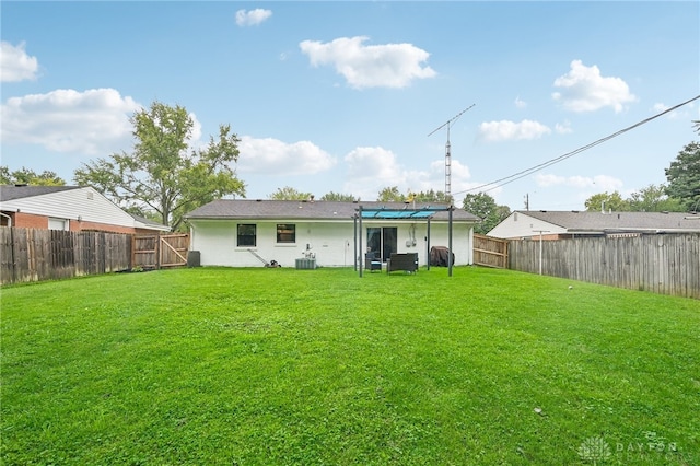 back of property with central air condition unit and a yard