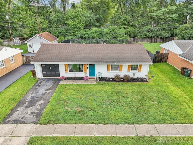 view of front of house featuring an outbuilding, a garage, and a front lawn