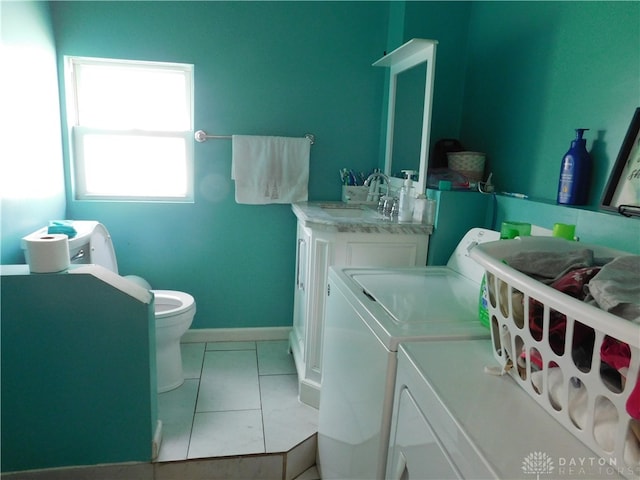 laundry area with sink, light tile patterned flooring, and independent washer and dryer