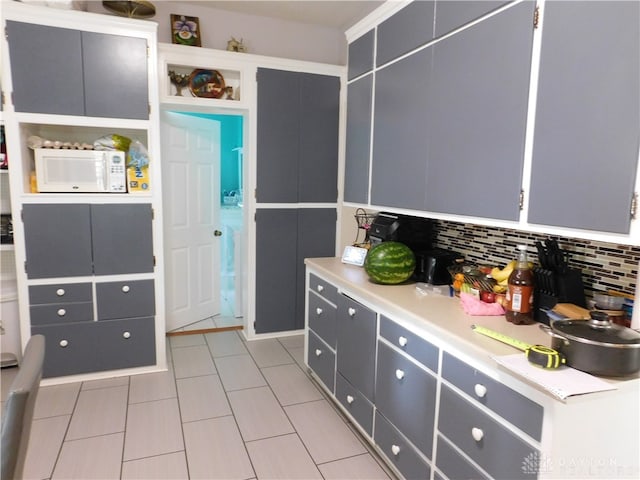 kitchen with decorative backsplash, gray cabinets, and light tile patterned floors