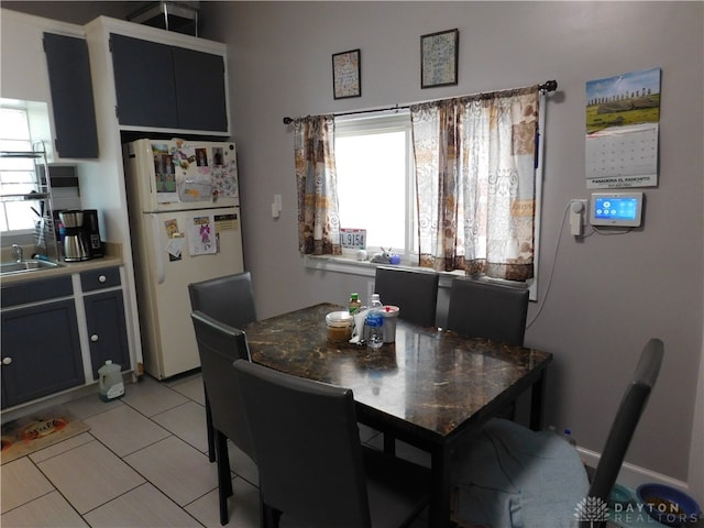 tiled dining space with a healthy amount of sunlight and sink