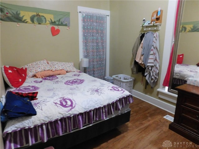 bedroom with dark hardwood / wood-style flooring