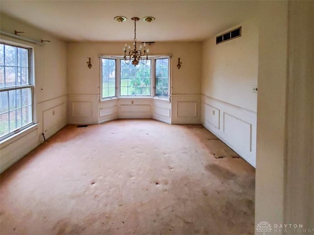 unfurnished dining area with a chandelier