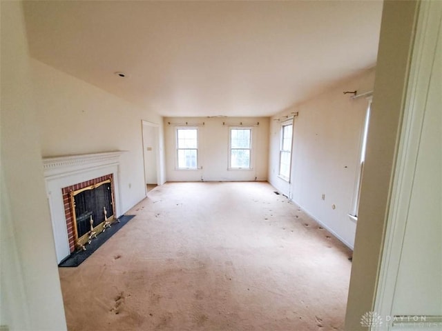 unfurnished living room with a brick fireplace and a wealth of natural light