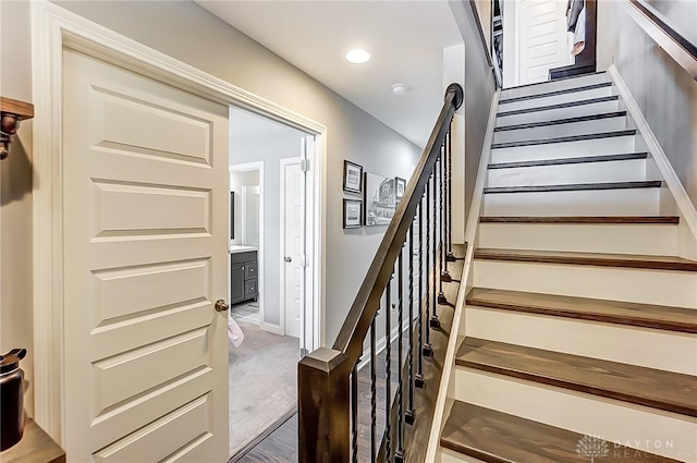 stairway featuring carpet flooring