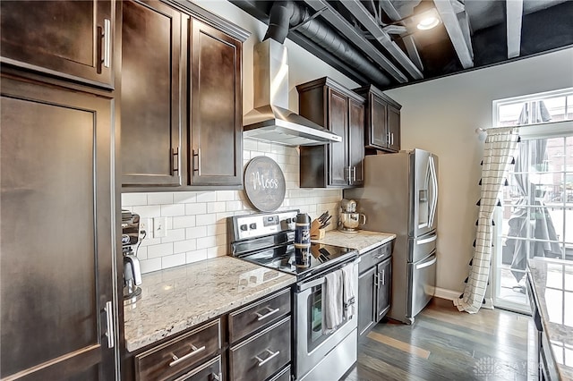 kitchen with wall chimney exhaust hood, dark hardwood / wood-style floors, dark brown cabinetry, appliances with stainless steel finishes, and backsplash