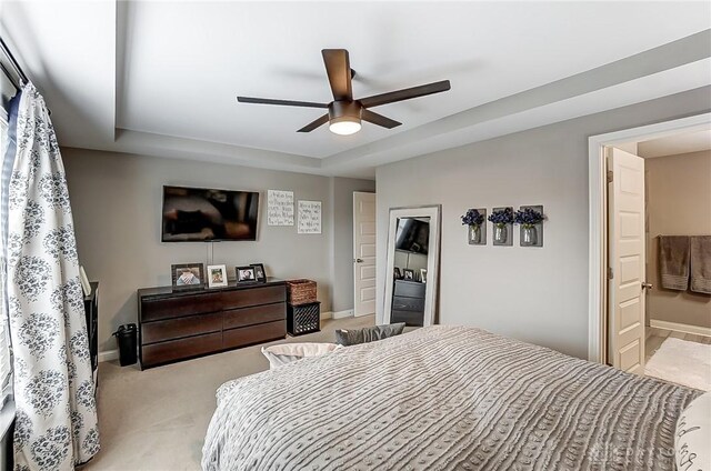 carpeted bedroom with ensuite bathroom and ceiling fan