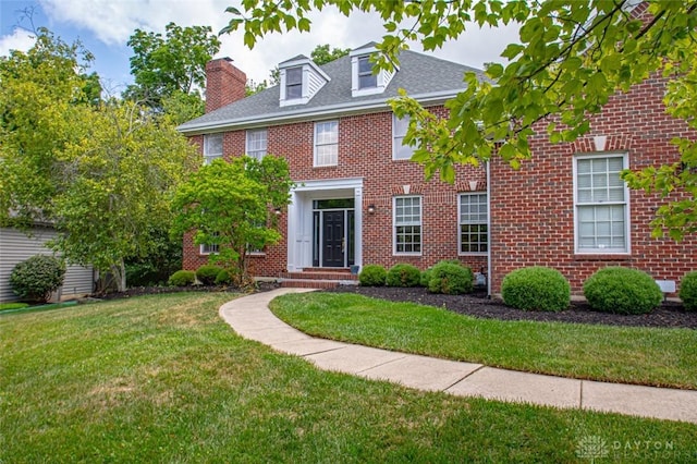 colonial-style house with a front lawn