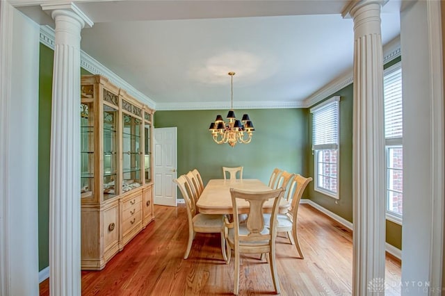 dining room with ornate columns, hardwood / wood-style floors, and a wealth of natural light